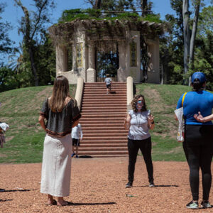 Grupo de personas participando de un recorrido del Parque Explorado, en el fondo de la imagen se ve el Templete ubicado en el Rosedal del Parque de la Independencia