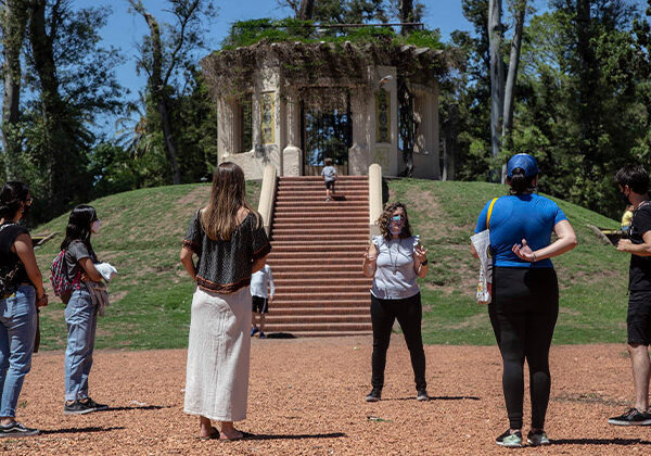 Grupo de personas participando de un recorrido del Parque Explorado, en el fondo de la imagen se ve el Templete ubicado en el Rosedal del Parque de la Independencia